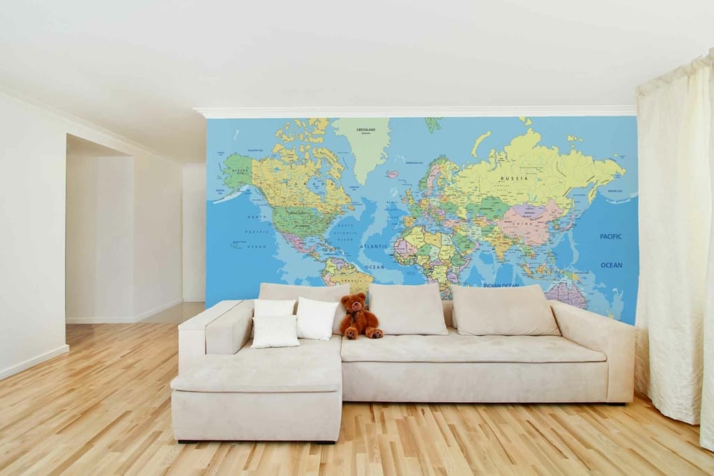 The wallpaper is a detailed world map mural, featuring earth tones and subtle shades of blue, green, and beige. It provides a geographical touch with intricate coastlines, countries, and continents clearly depicted. The design combines muted colors to create a sophisticated backdrop for the living room.