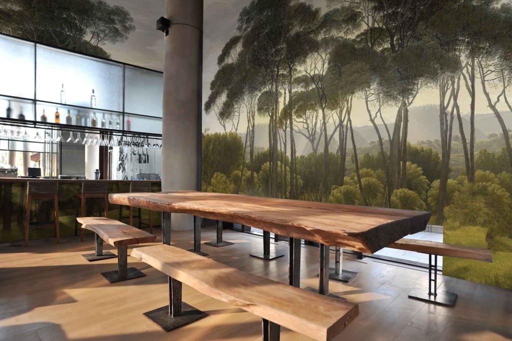 Henriks' back wall features a mural of trees in a lush forest. The wallpaper showcases various shades of green, with vibrant foliage and dappled sunlight filtering through the leaves. It provides an immersive, natural backdrop to the modern bar setting.