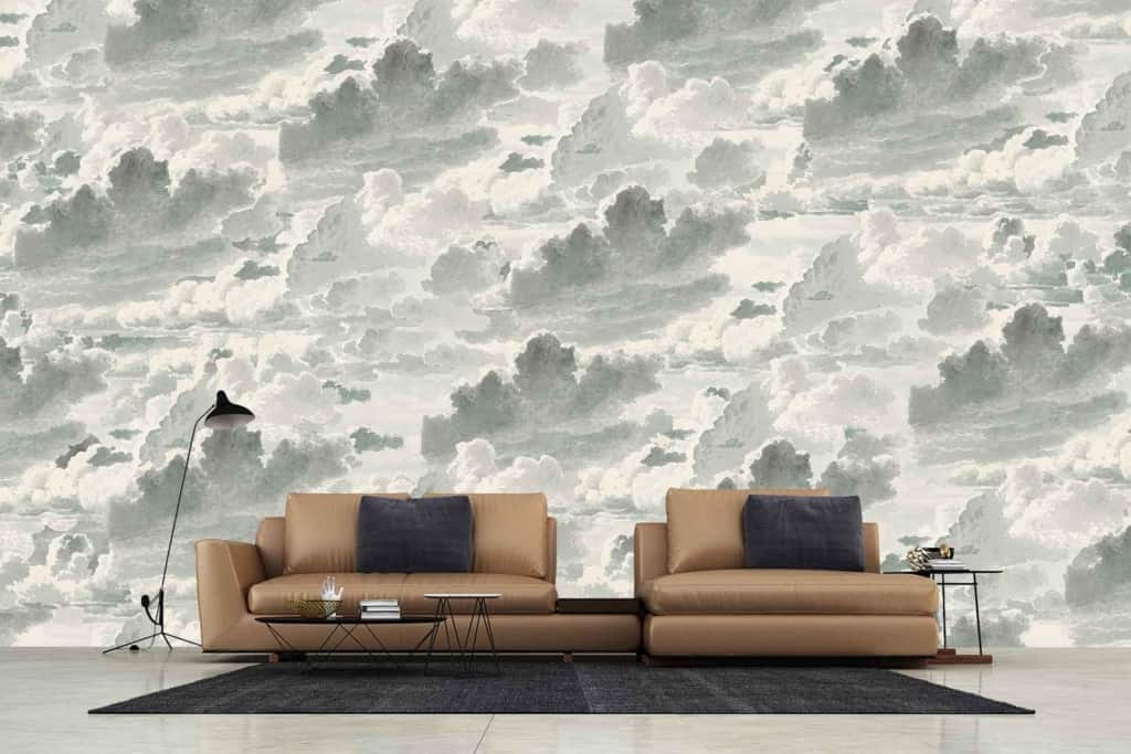 The wallpaper in the modern living room features a large Sirrus cloud-patterned mural in shades of gray and white, creating a serene, sky-like background. Key elements: clouds, gray hues, white tones.