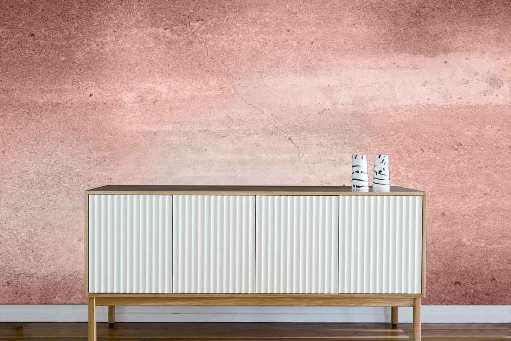 Textured, faded pink wall with subtle elegance.