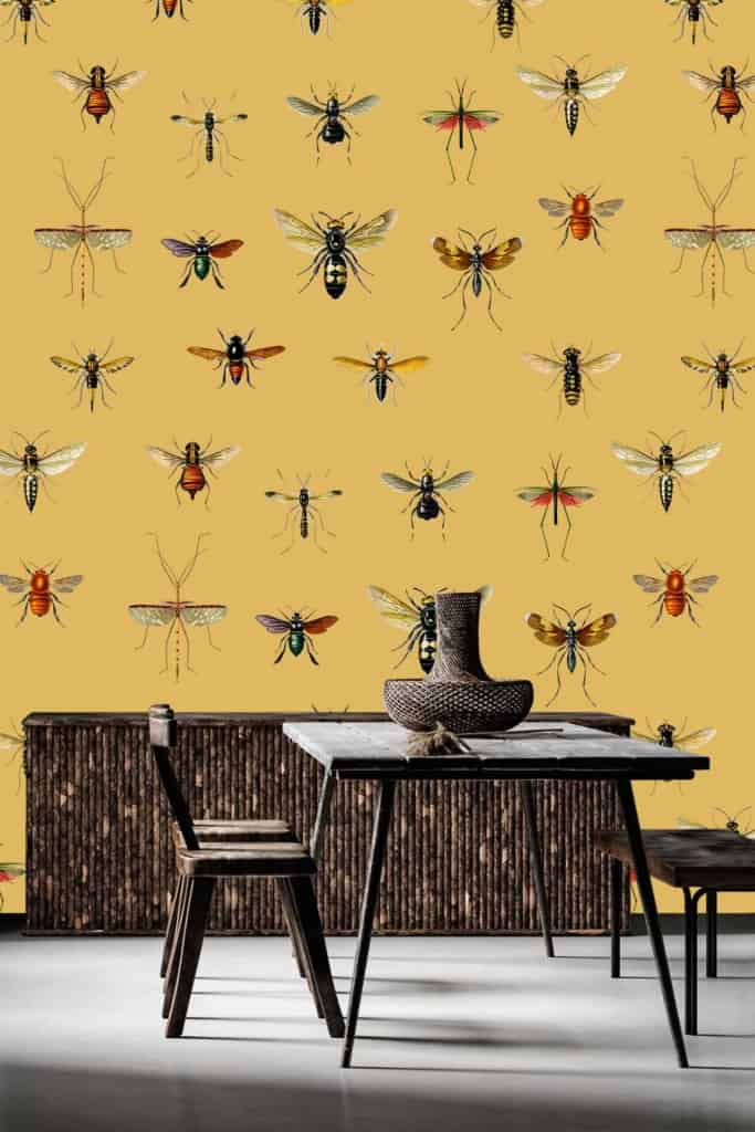 The wallpaper features illustrated insects in a variety of whimsical and eclectic designs. Predominantly yellow, it provides a vibrant backdrop reminiscent of an entomology study.