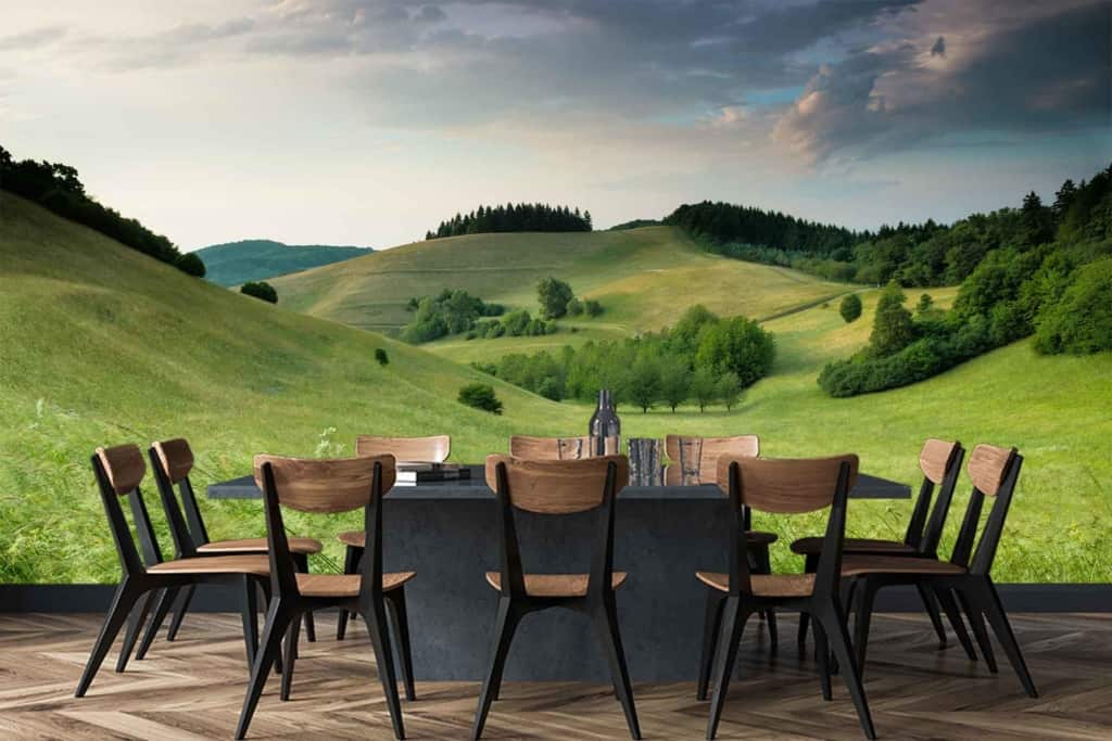 The wallpaper displays rolling green hills under a partly cloudy sky, creating an illusion of the outdoors with lush landscapes. Key elements include vibrant green tones, soft blue sky segments, and wisps of white clouds.