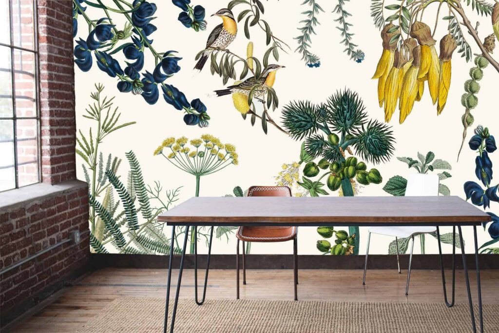 The wallpaper is a vibrant botanical mural inspired by Kruger National Park. It features colorful flowers, various species of birds, and lush green foliage. Key colors include bright reds, pinks, yellows, and different shades of green. Exotic patterns and detailed illustrations form an eye-catching design that brings nature indoors.