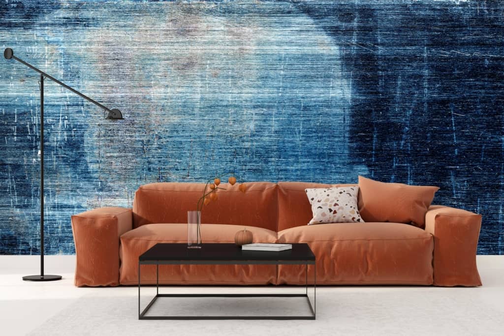 The wallpaper features a roughed-up, textured design with abstract art. It displays various shades of blue, including navy and sky blue, complemented by occasional strokes of white and hints of gray. Specks and scratches add to its distressed aesthetic.