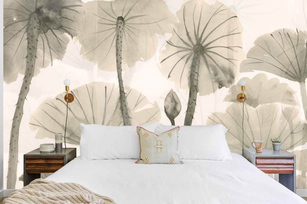 A bedroom wallpaper featuring large gray-green leaves. The mural highlights an intricate design with varying shades of gray and green, creating a lush, serene backdrop that adds depth and elegance to the room.