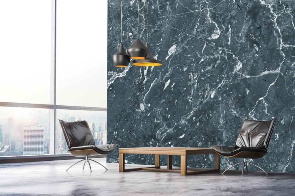 The wallpaper in this modern minimalist living room is a captivating dark marble accent with striking white veining. The deep, rich hues of the dark marble provide an elegant backdrop, while the intricate white veins add contrast and sophistication. This refined design perfectly complements the room's black leather chairs, wooden coffee table, and sleek black pendant lights—all set against the impressive floor-to-ceiling window showcasing a stunning cityscape view.
