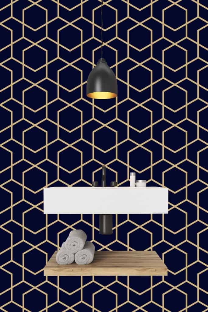 Contemporary bathroom features a striking geometric hexagon-patterned navy wallpaper, characterized by clean lines and sharp angles. The deep navy serves as the base color, complemented by subtle metallic accents within the hexagonal shapes for added depth and sophistication.