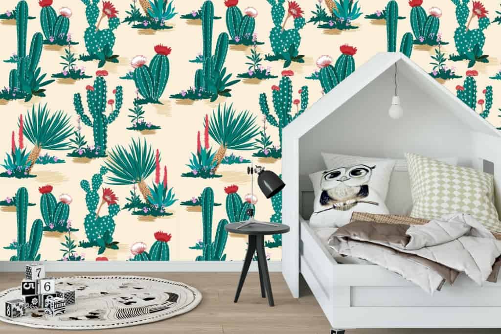 The wallpaper features a vibrant cactus and succulent pattern. It includes various shades of green, with splashes of pink, yellow, and brown detailing the desert plants. The design adds a cowboy flair to the decor.