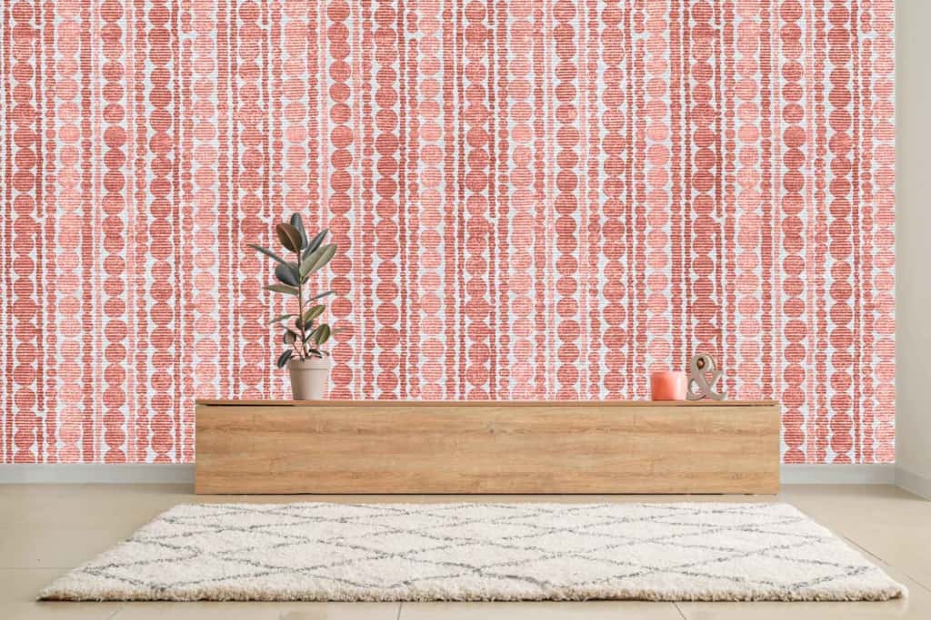 The room features a modern aesthetic with a striking red and white patterned wallpaper. The vivid red contrasts sharply against the crisp white, creating an eye-catching backdrop. Geometric and intricate designs dominate the wallpaper, adding a layer of visual complexity that enhances the minimalist decor. This bold choice of colors and patterns sets a dynamic tone for the space.