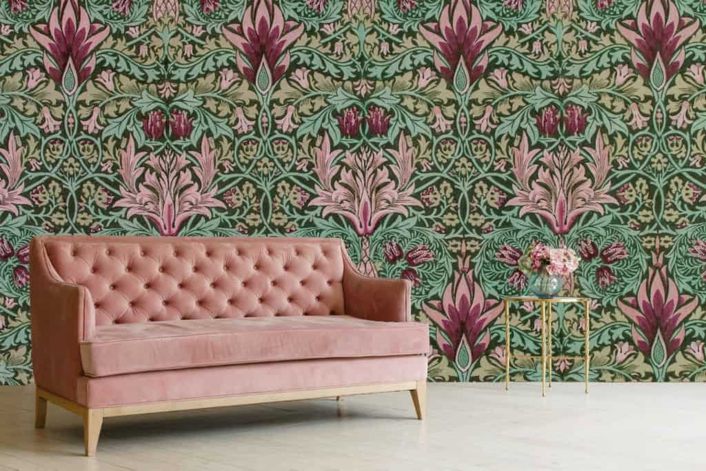 Intricate floral wallpaper in shades of green and pink features prominently. The pattern includes detailed, elegant flowers, evoking a delicate and charming atmosphere.