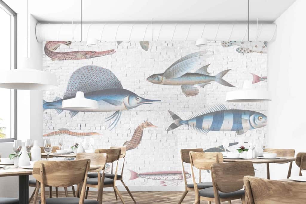 The wallpaper is a large mural featuring various fish, including a swordfish swimming upstream and flying fish. It incorporates marine themes with elements of underwater life. The colors are primarily shades of blue, white, and subtle grays to evoke oceanic scenery against the white brick backdrop.