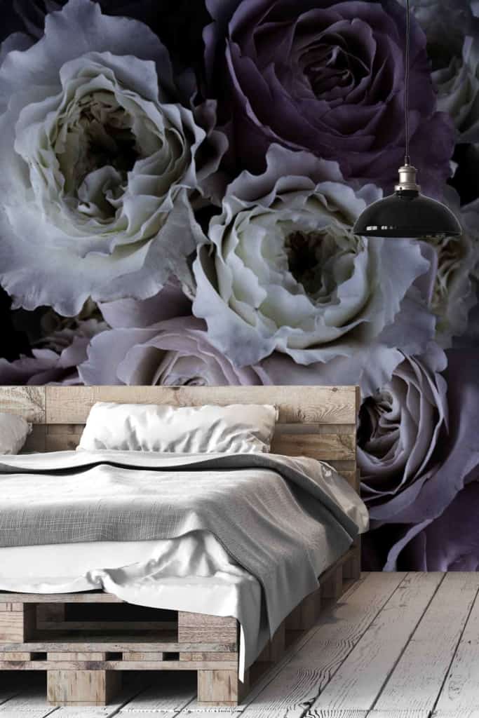 Large floral mural featuring white and purple roses. It adds a touch of romance to the room with its elegant and vibrant design. The wallpaper enhances the modern, rustic aesthetic by incorporating natural elements and sophisticated colors, creating a serene backdrop for the bedroom's décor.