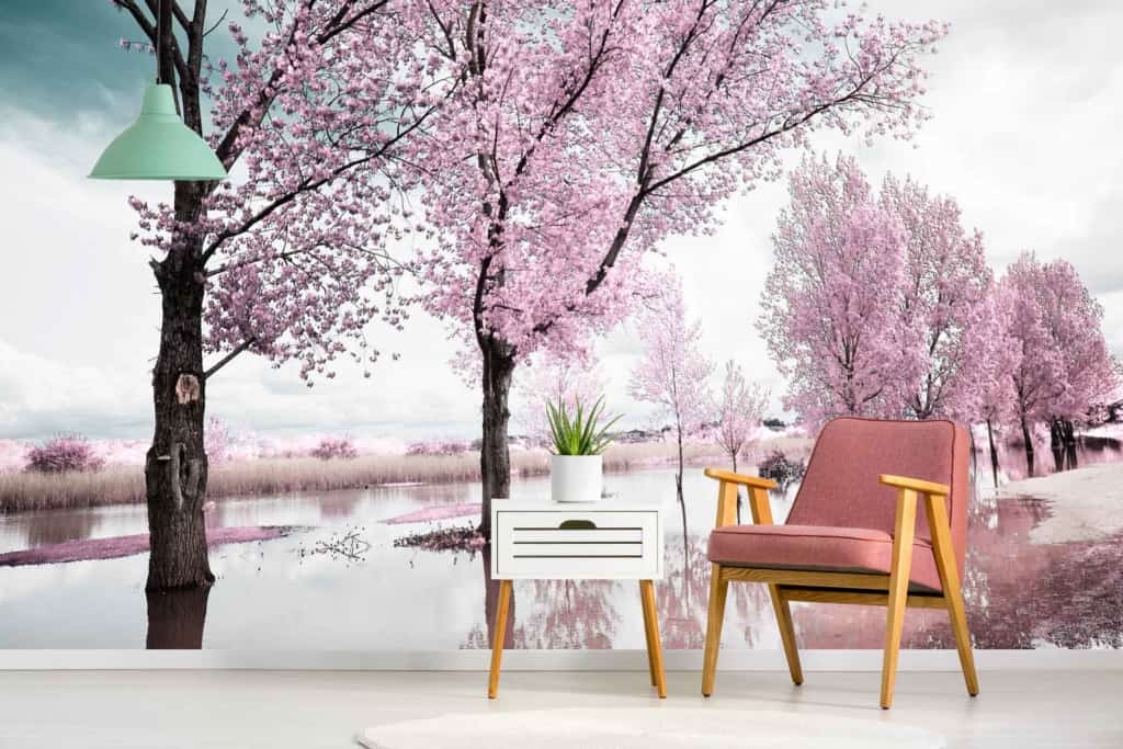 Decorative wall mural with blossoming pink cherry trees by a reflective body of water; evokes nostalgia; features elements like cherry blossoms, trees, and water; primary colors: pink and blue.