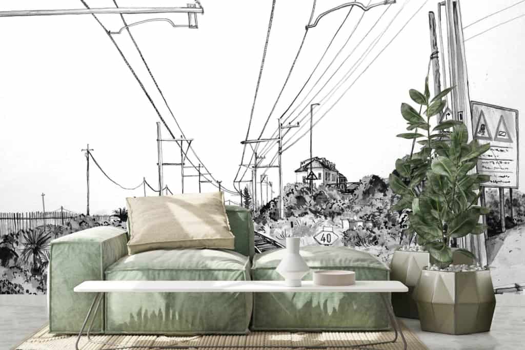 A black-and-white mural depicting power lines, road signs, and a rail crossing in Kalk Bay.