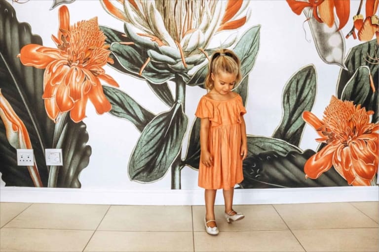 Vibrant floral mural featuring large green leaves and orange flowers.