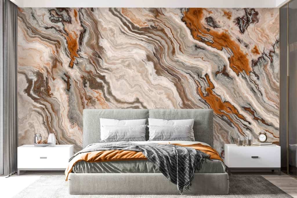 The wallpaper behind the bed features a striking, abstract marble design with elements in shades of orange, brown, beige, and gray.