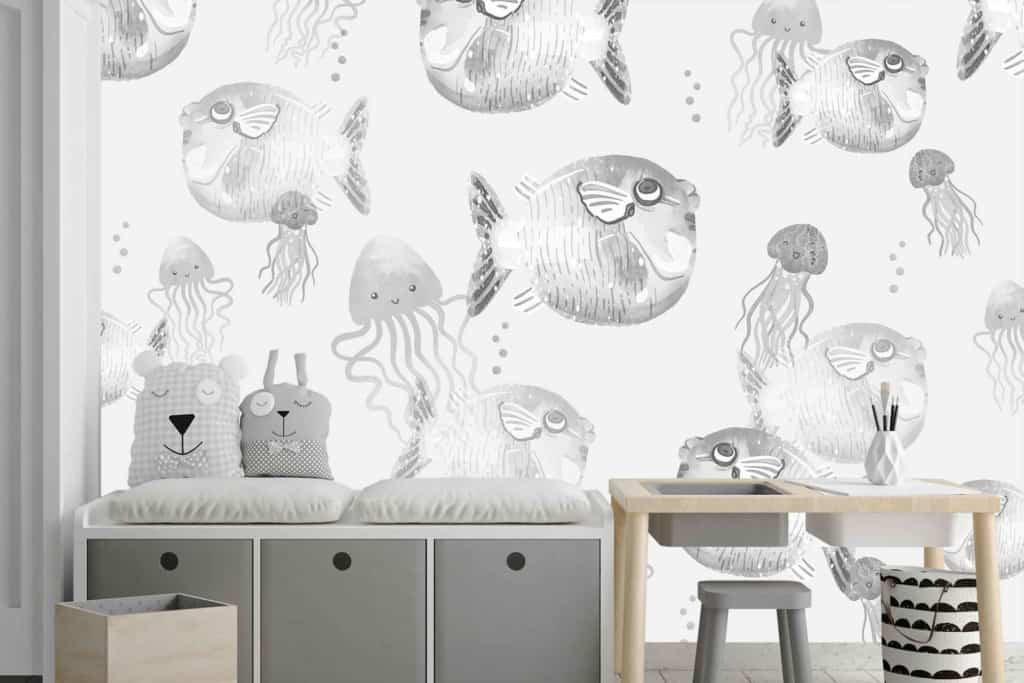 Wall decorated with playful, hand-drawn sea creatures: jellyfish and pufferfish. White and grey tones.