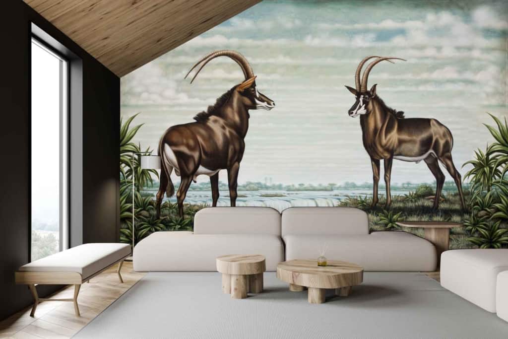 Modern living room mural: two antelopes with long, curved horns facing each other in a natural landscape; striking image of a Black Rhino; vibrant greens and earthy browns dominate; highlights of white and black for animal details.