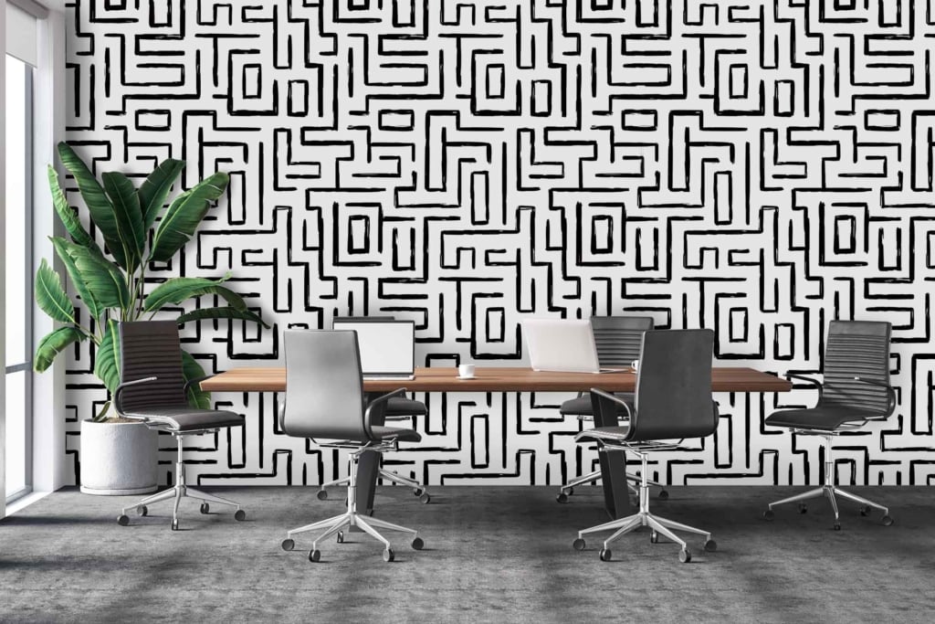 Black and white geometric patterned wall. Angular shapes, interlocking lines. Predominantly monochromatic with bold contrasts.