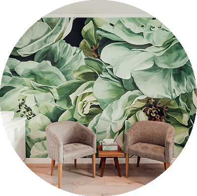 A large, vibrant mural of green leaves and flowers.