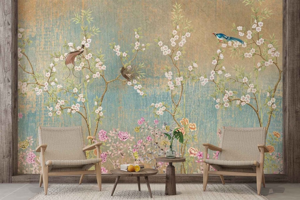 The wallpaper features detailed depictions of birds perched on branches, adorned with pink flowers and lush green foliage. The artwork showcases intricate elements including feathers, petals, and leaves in soft pastels and vibrant greens. Pinks, greens, and delicate bird illustrations dominate the serene mural.