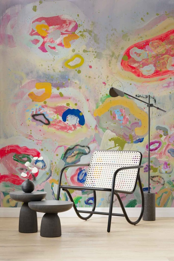 Abstract, colorful mural with splashes of pink, yellow, green, and blue.