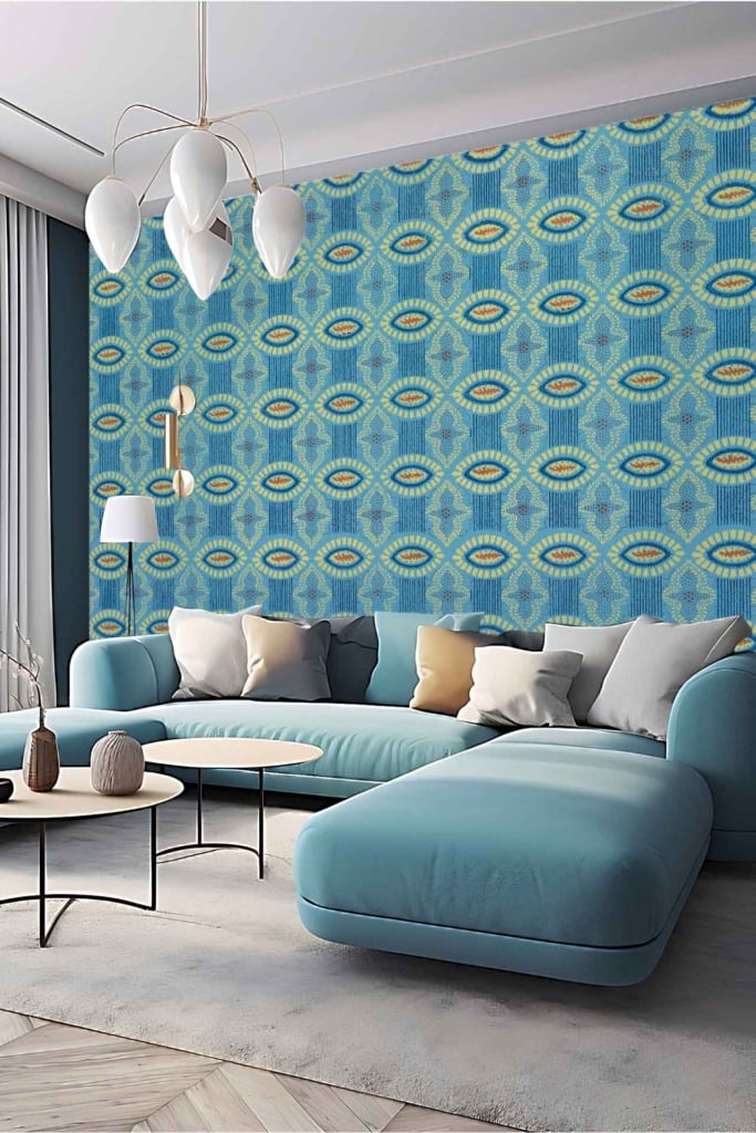 A modern living room featuring a blue and green geometric patterned feature wall. Elements include various shades of blue and green in varying geometric shapes like triangles, squares, and hexagons. The wallpaper integrates bold, modern design with a mix of vibrant azure blues, forest and lime greens to create a striking focal point.