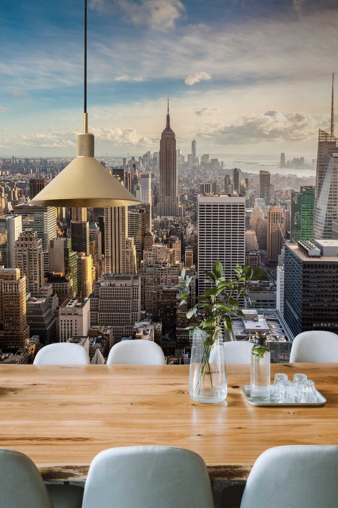 Wallpaper featuring an elegant cityscape design with intricate skyscrapers, including the Empire State Building. Key elements are detailed buildings in shades of gray and white, subtle tonal variations representing windows and architectural features. Touches of soft blue to mimic the sky and muted hues for a sophisticated urban look. Delicate outlines and shading give a three-dimensional effect that complements modern decor settings.