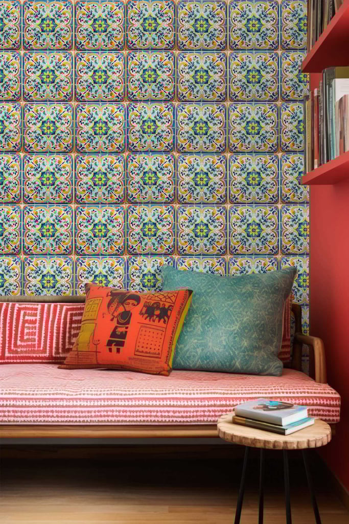 Colorful patterned wallpaper featuring intricate designs and bright hues. Elements include vibrant reds, deep oranges, various shades of green, and subtle blue accents reminiscent of Mediterranean motifs. Perfect for adding a lively, intricate backdrop to any cozy seating area.