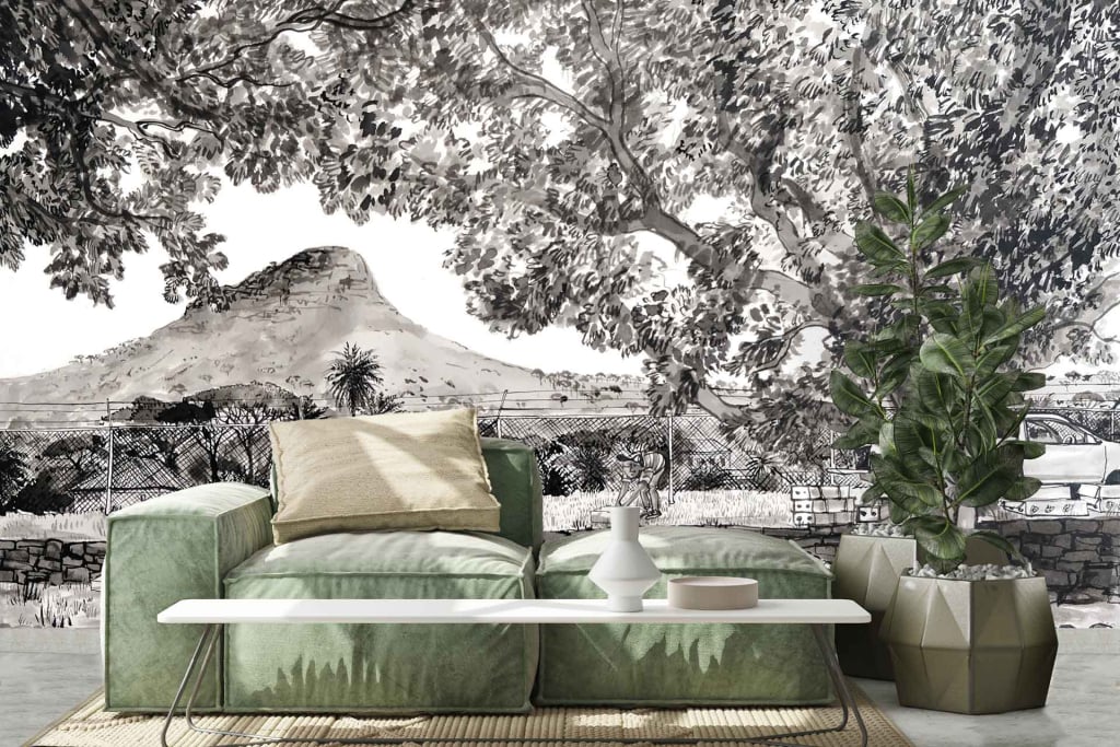 The wallpaper dominates the room with a stunning monochrome mural, capturing the essence of a majestic mountainous landscape. Shades of black, white, and varying grays blend harmoniously to depict towering mountains adorned with lush trees. A delicate fence meanders through the scene, adding depth and intrigue to the composition. This grayscale design casts an elegant and timeless atmosphere over the living space.