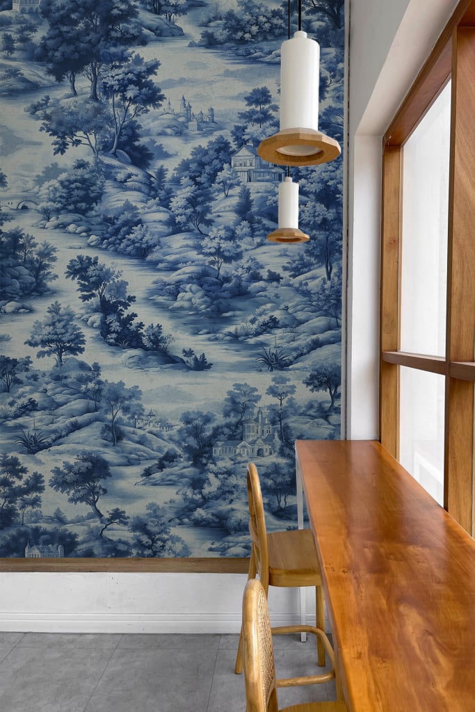 The wallpaper features blue and white toile depicting pastoral scenes. Key elements include elegant patterns, detailed landscapes, and historical motifs. The primary colors are blue and white.
