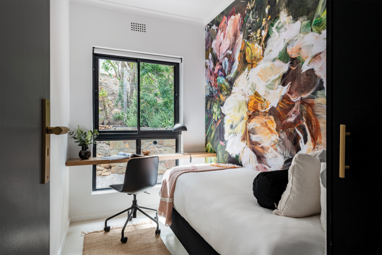 Abstract floral mural featuring bold, sweeping brushstrokes in shades of deep blue, vibrant green, and soft lavender. Delicate hints of gold and cream interlace with dynamic shapes suggesting petals and leaves. The design is layered with depth and texture, creating a sense of whimsy and tranquility.