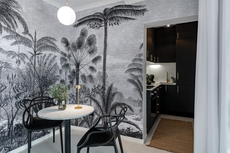 Black and white tropical mural featuring palm leaves and exotic foliage.