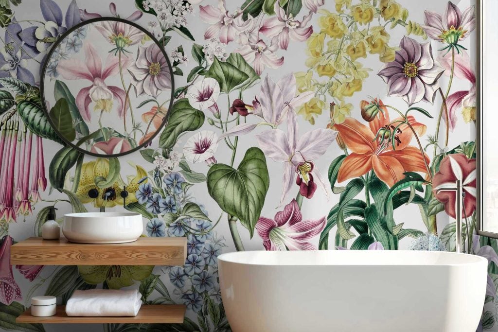 The vibrant floral wallpaper features colorful flowers in hues of pink, red, blue, and yellow, accented by lush green leaves. The design resembles a tidal pool with its dynamic arrangement. This garden-like atmosphere is rich with nature-inspired elements and lively colors.