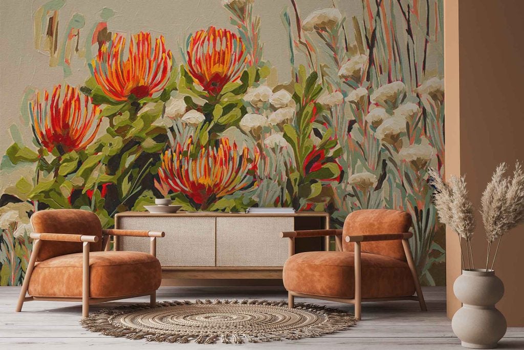 Vibrant floral wallpaper inspired by Blombos pincushions, featuring bold red and orange flowers with lush green foliage. The mural displays intricate botanical details and organic forms, with dynamic pops of color against a contrasting background.
