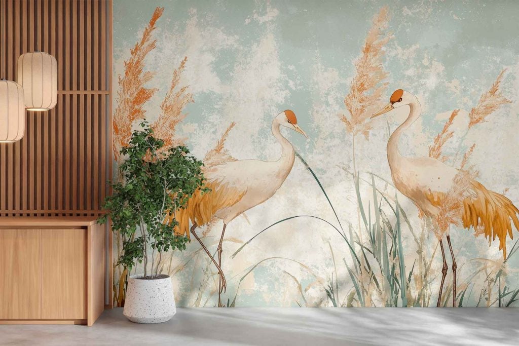 Wallpaper features: two elegant cranes, tall grasses, reeds, gentle breeze effect; softly textured background in pastel colors (soft blues, blush pinks, gentle greens); graceful bird silhouettes; subtle botanical elements.