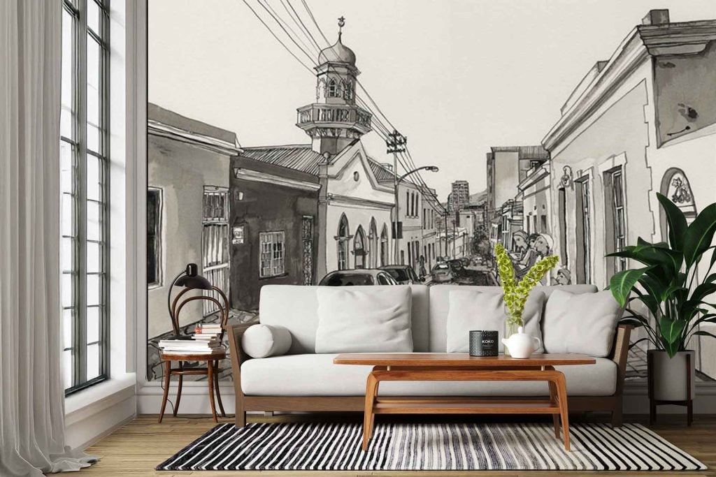 The wallpaper is a large wall mural depicting a black-and-white city street scene. Key elements in the mural include historic buildings with ornate architectural details, a prominent clock tower as a focal point, cobblestone streets, and vintage street lamps. The entire mural features varying shades of gray, black, and white for a dramatic monochrome effect.