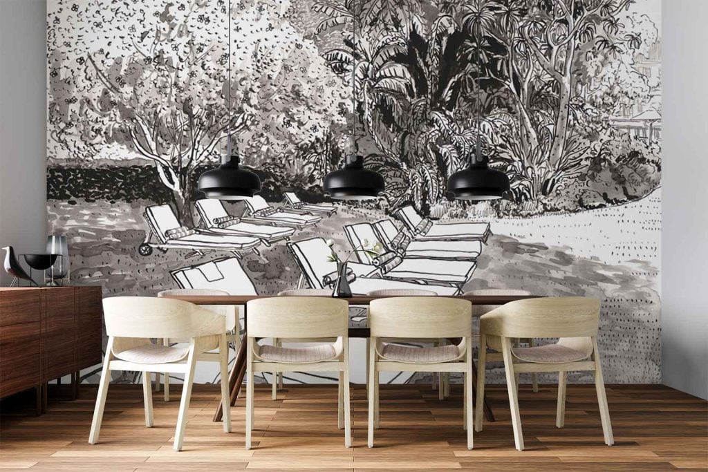 The wallpaper features a mural with abstract black-and-white lounge chairs and stylized green foliage. The design emphasizes bold, graphic chair outlines in contrasting monochrome, set among organic shapes of lush greenery in various shades of green, creating a modern, artistic backdrop.