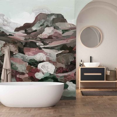 Abstract landscape mural wallpaper features soft, overlapping mountain shapes in hues of terracotta, blush pink, sage green, and deep teal. Stylized foliage in mustard yellow and olive green adds depth. The design sits under elegant arches, creating a contemporary yet artistic statement.