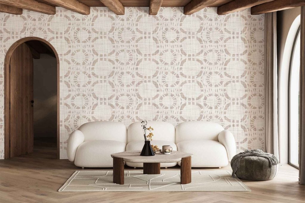 The wallpaper features a modern geometric design with interlocking shapes in muted tones of beige, cream, and soft gray. Its pattern includes angular lines and repeating diamond motifs, creating visual interest while maintaining a warm, inviting atmosphere.