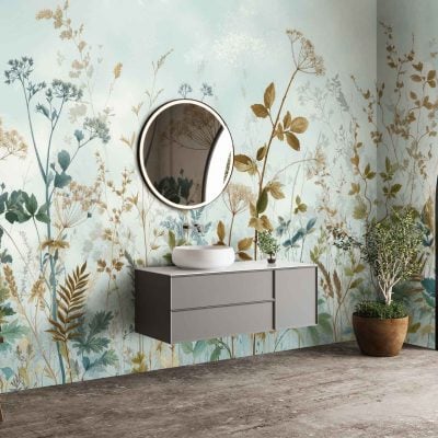 Botanical wallpaper featuring lush green leaves, delicate ferns, and subtle eucalyptus branches intertwined with muted pastel flowers. The color palette includes deep forest green, sage, soft blush pinks, creamy whites, and hints of golden yellow. Patterns are layered for a natural, organic texture with occasional touches of watercolor blue mimicking mountain mist.