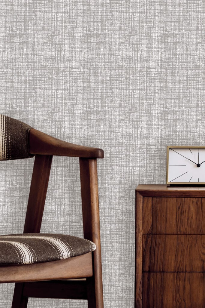 Textured light grey wallpaper with subtle patterns, featuring soft variations in tone and delicate raised detailing.