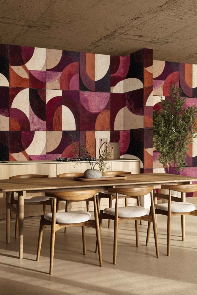 The wallpaper features a bold geometric pattern with shapes in pink, red, and beige tones, creating a striking modern and artistic backdrop.