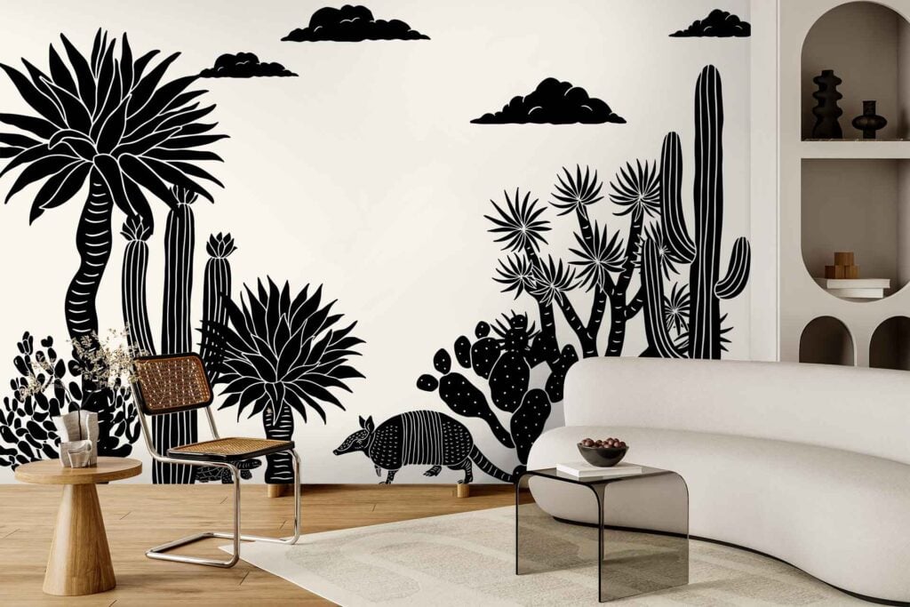 Black and white mural wallpaper featuring bold desert plants, an armadillo, and clouds in a Left Of Centre artistic style.
