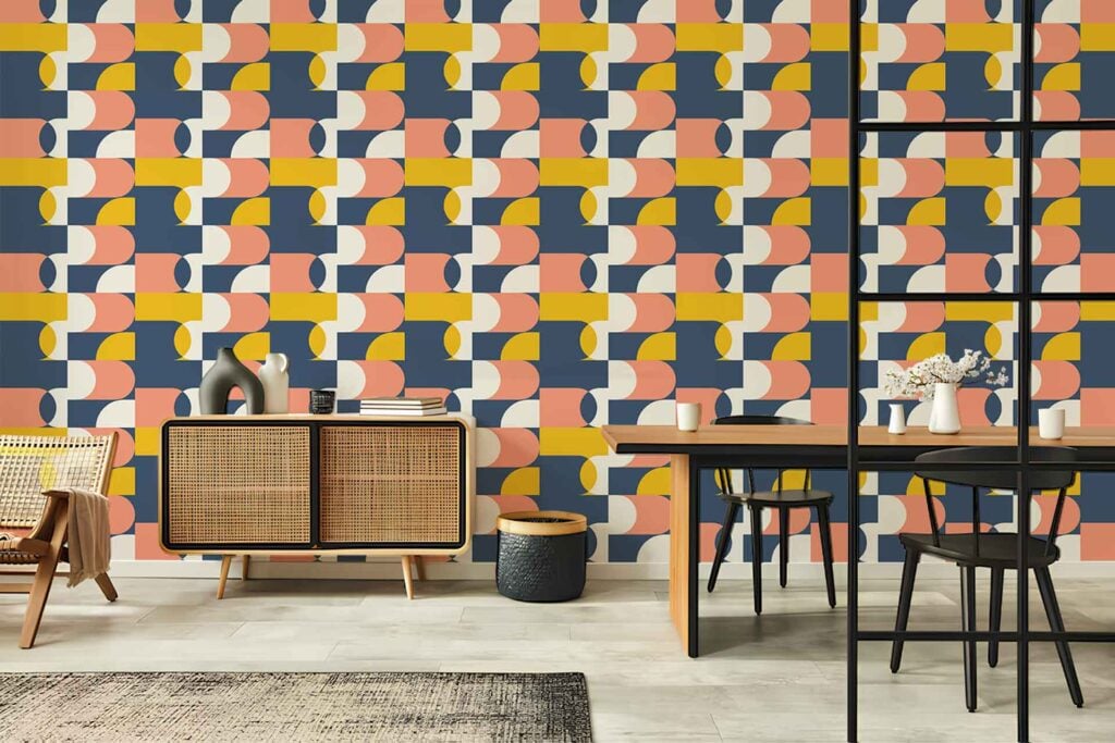 Geometric patterned wallpaper in yellow, pink, blue, and white featuring modern shapes and bold color blocks; eye-catching design element.