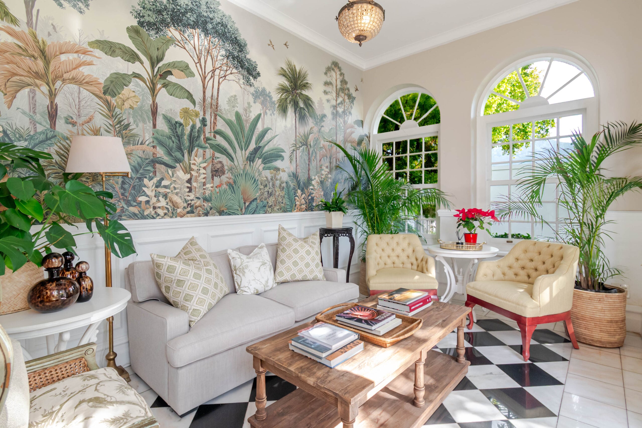Tropical mural wallpaper featuring lush green leaves, vibrant florals, and bursts of bold colors; botanical elements in vivid greens, pinks, corals, and yellow stand out against a soft background.