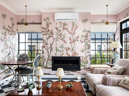 The living room’s floral wallpaper features delicate blossoms and leafy patterns in soft pink, green, and cream hues, creating a vintage-inspired backdrop.
