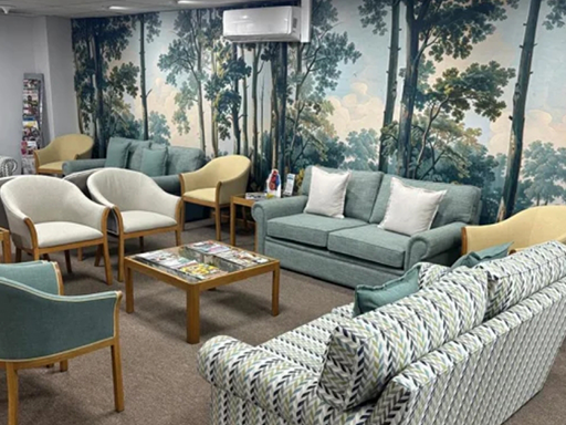 The wallpaper is a nature mural featuring tall trees, with greens and browns prominent in the foliage and trunks. The design brings an outdoor forest scene into the room.
