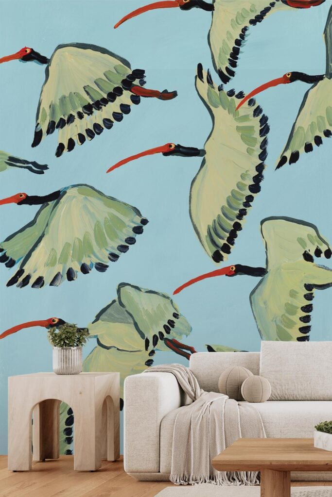A wallpaper with stylized ibises featuring green wings and red beaks, flying against a light blue background.