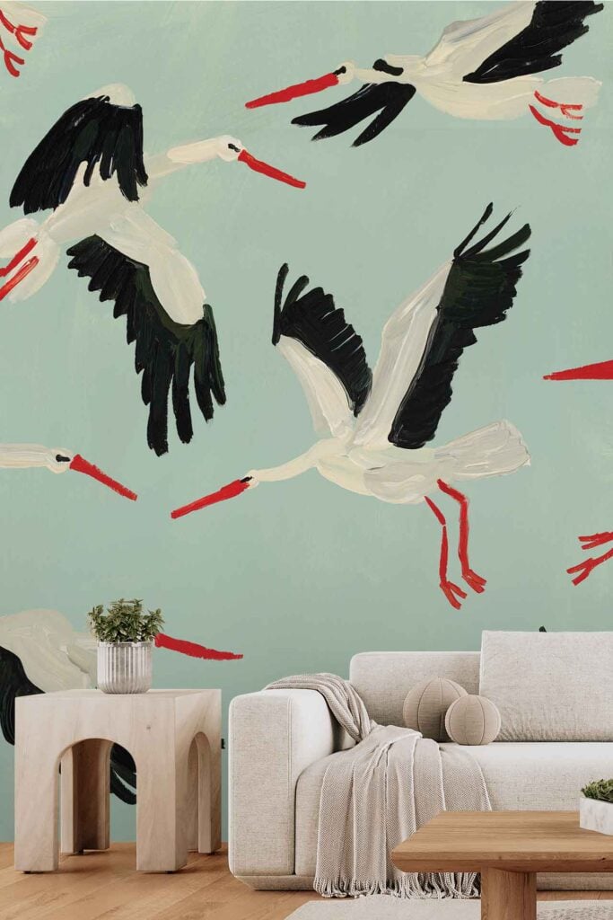 Wallpaper featuring illustrated white storks with black wings and red beaks, flying on a light green background.